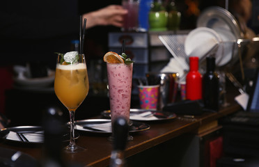 Glasses with different cocktails on bar counter