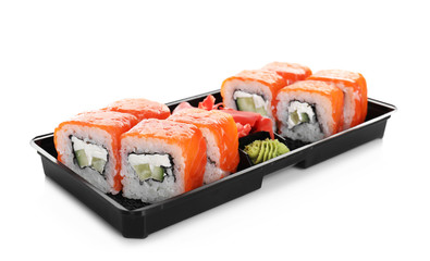 Box with tasty sushi rolls on white background. Food delivery