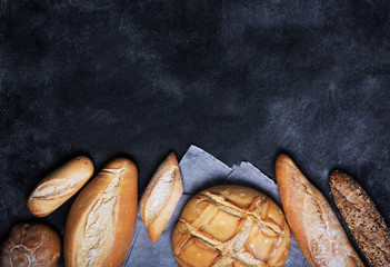 Fresh bread on a black chalkboard. Top view with copy space
