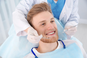 Dentist examining patient's teeth in modern clinic