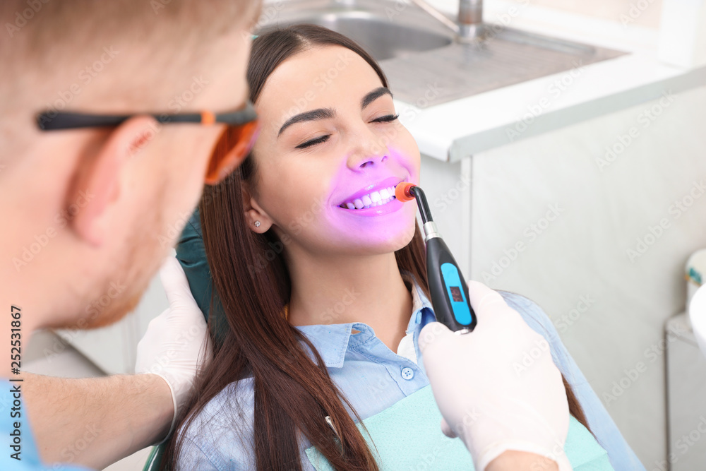 Poster professional dentist working with patient in modern clinic. teeth whitening