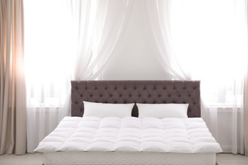 Fototapeta na wymiar Comfortable bed with new mattress near window in room. Healthy sleep