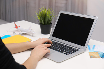 Professional manager working at laptop in travel agency, closeup