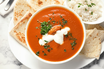 Delicious butter chicken served on marble table, top view. Traditional Murgh Makhani dish