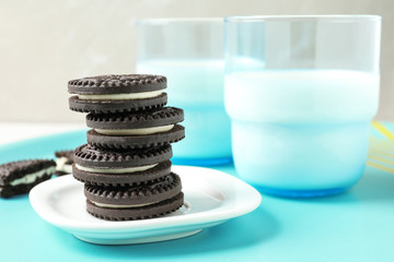 Tasty chocolate cookies with cream and milk on tray. Space for text