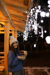 Woman with glass cup of mulled wine at winter fair