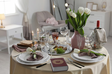 Festive Passover table setting with Torah at home. Pesach celebration