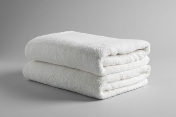 Fototapeta na wymiar Fresh soft folded towels on light background