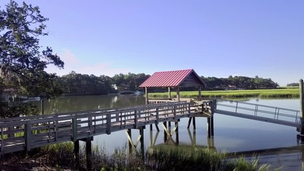 Slow, dolly shot of coastal dock and boathouse in South Carolina.