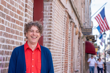 Portrait of a handsome man smiling, laughing and happy while visiting the French Quarter in New...