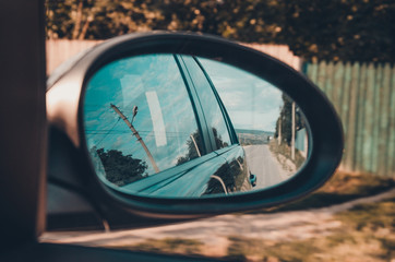 Lonely road seen through rear mirror