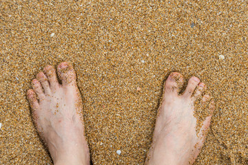 Relaxing at a beach, with your feet in the wet sand