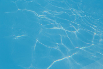 Blue pool water with sun reflections