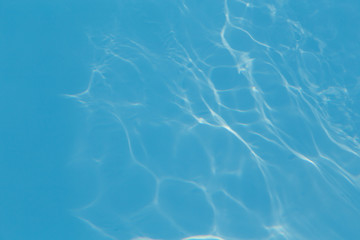 Blue pool water with sun reflections