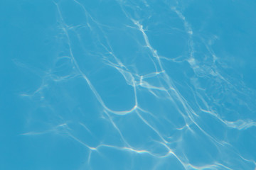 Blue pool water with sun reflections
