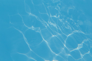 Blue pool water with sun reflections