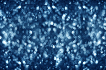 Blurred dark blue shiny glitter bokeh background, defocused soft blue silver shimmer backdrop design, white shining round bubbles blur effect, festive New Year and Christmas holiday banner concept