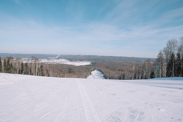 Winter mountain view from above. View down from the mountain in winter. Winter landscape. Winter in Siberia.