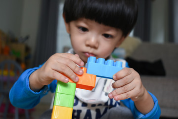 cute boy playing block toy creative learning and using small muscle of baby finger hand