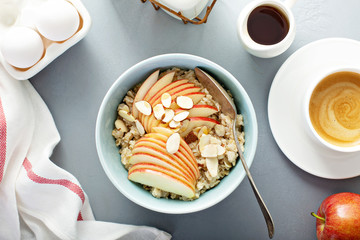 Healthy oatmeal with sliced apple and almonds for breakfast overhead view