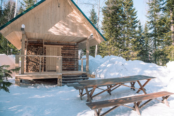 Wooden hut in the winter forest. Ski resort. Winter forest. Wooden bath in the forest. Winter landscape.