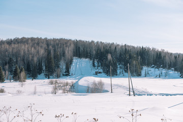 Village in the winter. Houses in Siberia under the snow. Buildings in the snow.