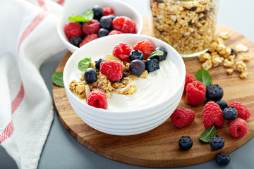 Plain yougurt with granola and berries on side, fresh, healthy and colorful breakfast