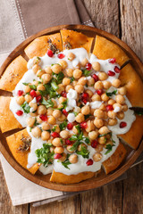 Fatteh Pita with Chickpeas and Yogurt traditional arabic dish closeup on a plate. Vertical top view