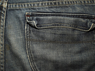 Old faded blue jeans. Macro. Pocket on old blue jeans.