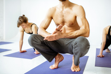 People resting during the yoga training in the studio, close-up on the male hands