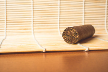 Fototapeta na wymiar Strong cigar on white bamboo mat.