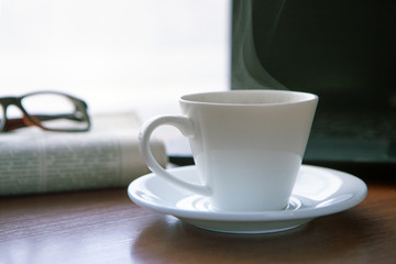 Newspaper with computer on table. Coffee break.