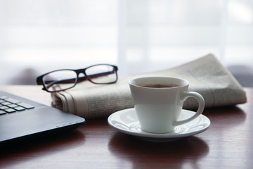 Newspaper with computer on table. Coffee break.