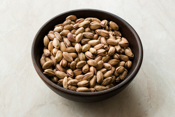 Pistachio Nuts with Shell in Wooden Bowl.