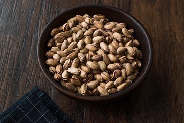 Pistachio Nuts with Shell in Wooden Bowl.