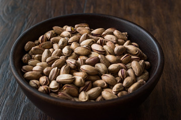 Pistachio Nuts with Shell in Wooden Bowl.