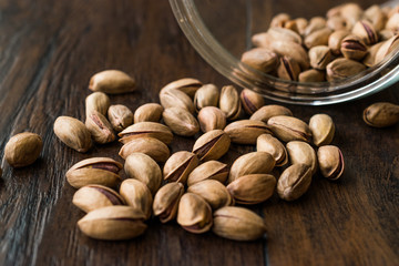 Pistachio Nuts with Shell on Dark Wooden Surface.