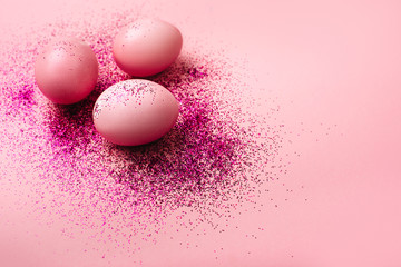Naklejka na ściany i meble Pink Easter eggs on a pink background with sparkles