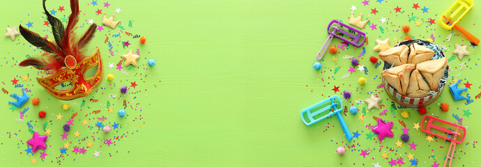 Purim celebration concept (jewish carnival holiday) over wooden green background. top view, flat lay. banner