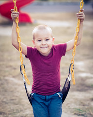 Little boy swinging on a swing