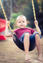 Little boy swinging on a swing