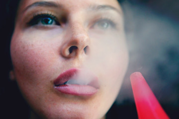 The girl smokes a hookah. Smoke closeup