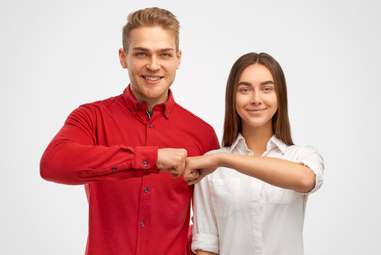 Beautiful partners give fist bump, agree to work together, have happy facial expressions rejoice success and cooperation, have toothy smiles