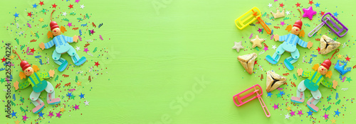 Purim celebration concept (jewish carnival holiday) over wooden green background. top view, flat lay