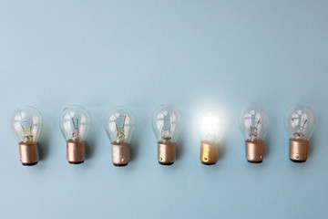 .Row of switched off light bulbs with one switched on. Concept of having idea and creativity