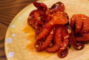 Ojing-O-Bokeum, Fried squid with Korean sauce and sesame oil, serving on yellow plate