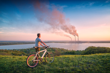 Man with bicycle looking to the power station