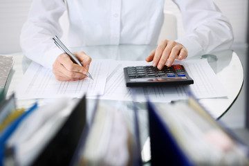 Unknown bookkeeper woman or financial inspector  making report, calculating or checking balance, close-up. Business portrait. Audit or tax concepts