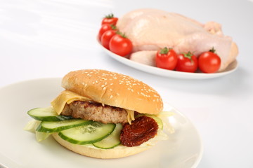 cheeseburger, chicken cutlet, bacon, tomatoes and slices of cheese, dressed with sauce and green salad for a restaurant menu on a white isolated background