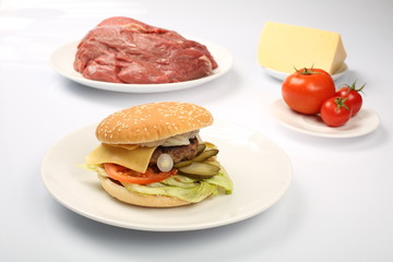 cheeseburger, chicken cutlet, bacon, tomatoes and slices of cheese, dressed with sauce and green salad for a restaurant menu on a white isolated background
